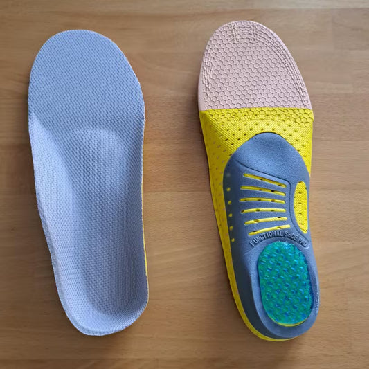 Two shoe insoles, one blue and white, the other yellow and blue, on a wooden surface.