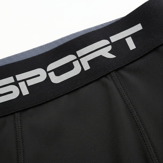 Black athletic shorts with a visible brand logo on the waistband against a white background saying sport