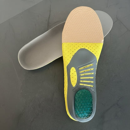 Close-up of a shoe insole with yellow and gray design on a dark surface