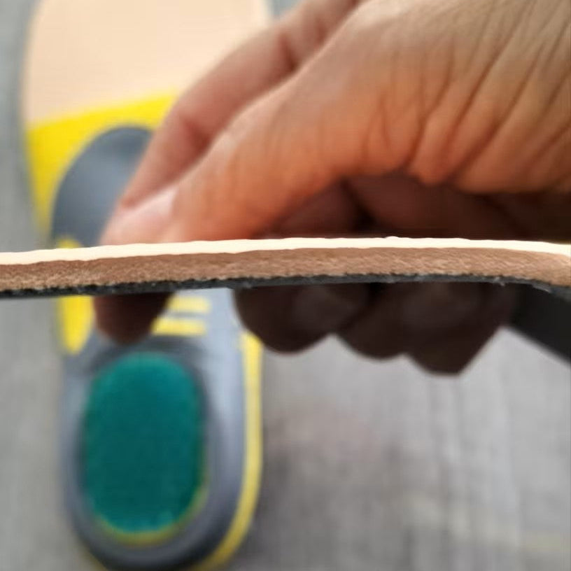 Close-up of a hand holding a skateboard deck with a blurred background
